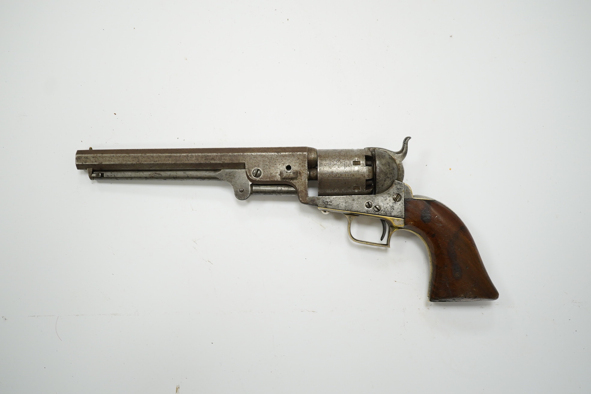 A six shot .36 Colt Navy single action percussion revolver, number 1875 (matching), regulation under lever rammer, signed barrel, roll engraved cylinder, brass mounts with traces of plating and single piece walnut grip,